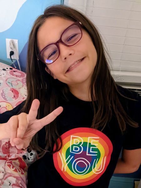 beatrice-wearing-glasses-giving-peace-sign-in-be-you-pride-shirt